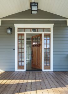 Vertical shot of wooden front door of an upscale home with windows