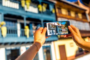 Female hands photographing with smart phone old colorful balconies in Santa Cruz de la Palma in Spain